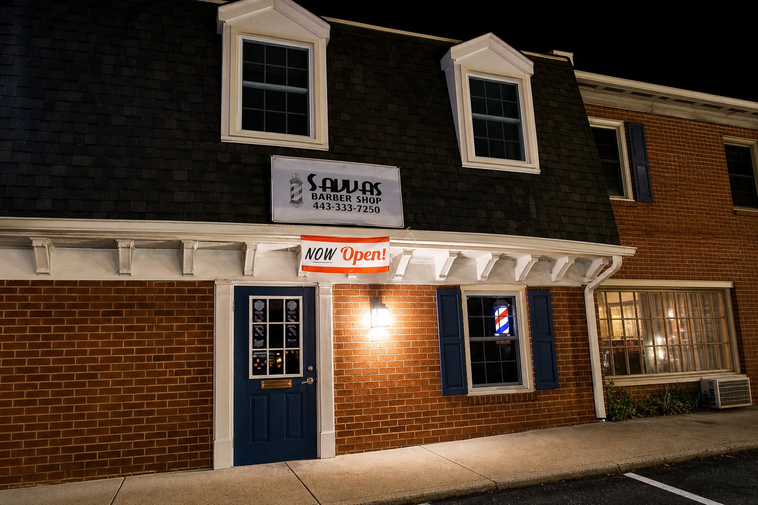 Exterior view of Savvas Barbershop with blue door, sign, banner, and barber pole